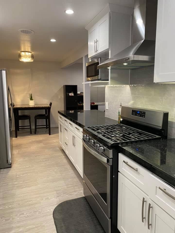 A kitchen with stainless steel appliances and white cabinets