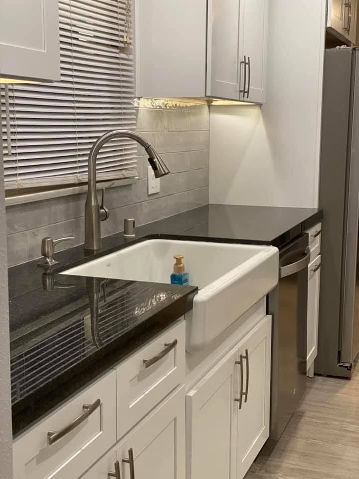 A kitchen with a sink , faucet and dishwasher.