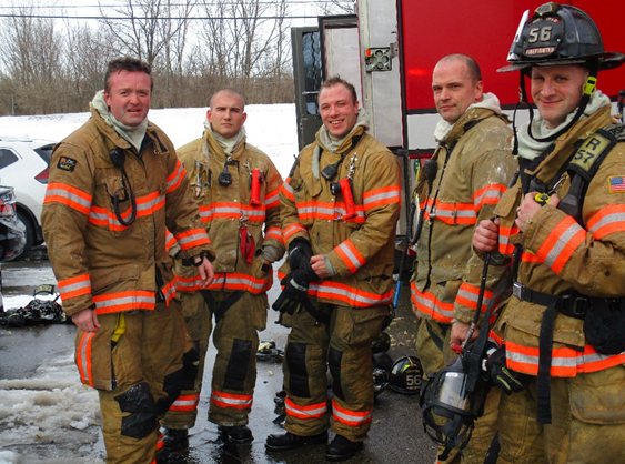 Fire Fighter Smiling At Taking Photo Point Location With Person Inside Of Inside Three People With Star Fire Extinguisher — Cincinnati, OH — Kramer & Associates Fire and EMS Consulting