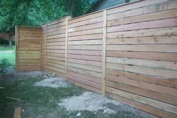 Wooden privacy fence in a yard, partially obscuring the background.