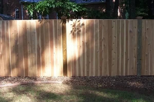 Wooden privacy fence in a backyard setting.