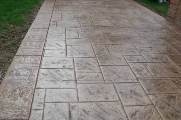Stamped concrete driveway with rectangular stone pattern, tan color.