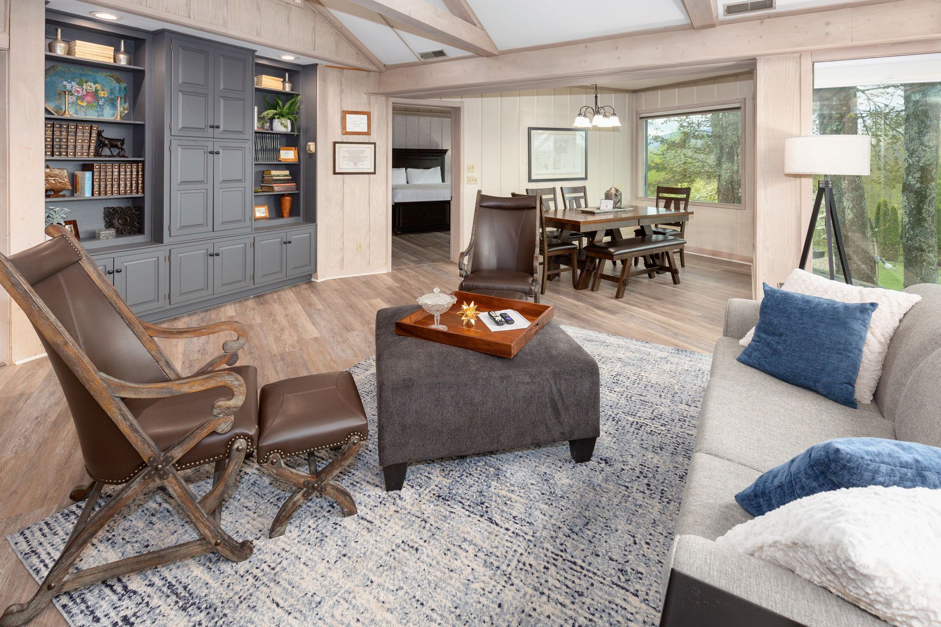 A living room with a couch , chairs , ottoman and rug.