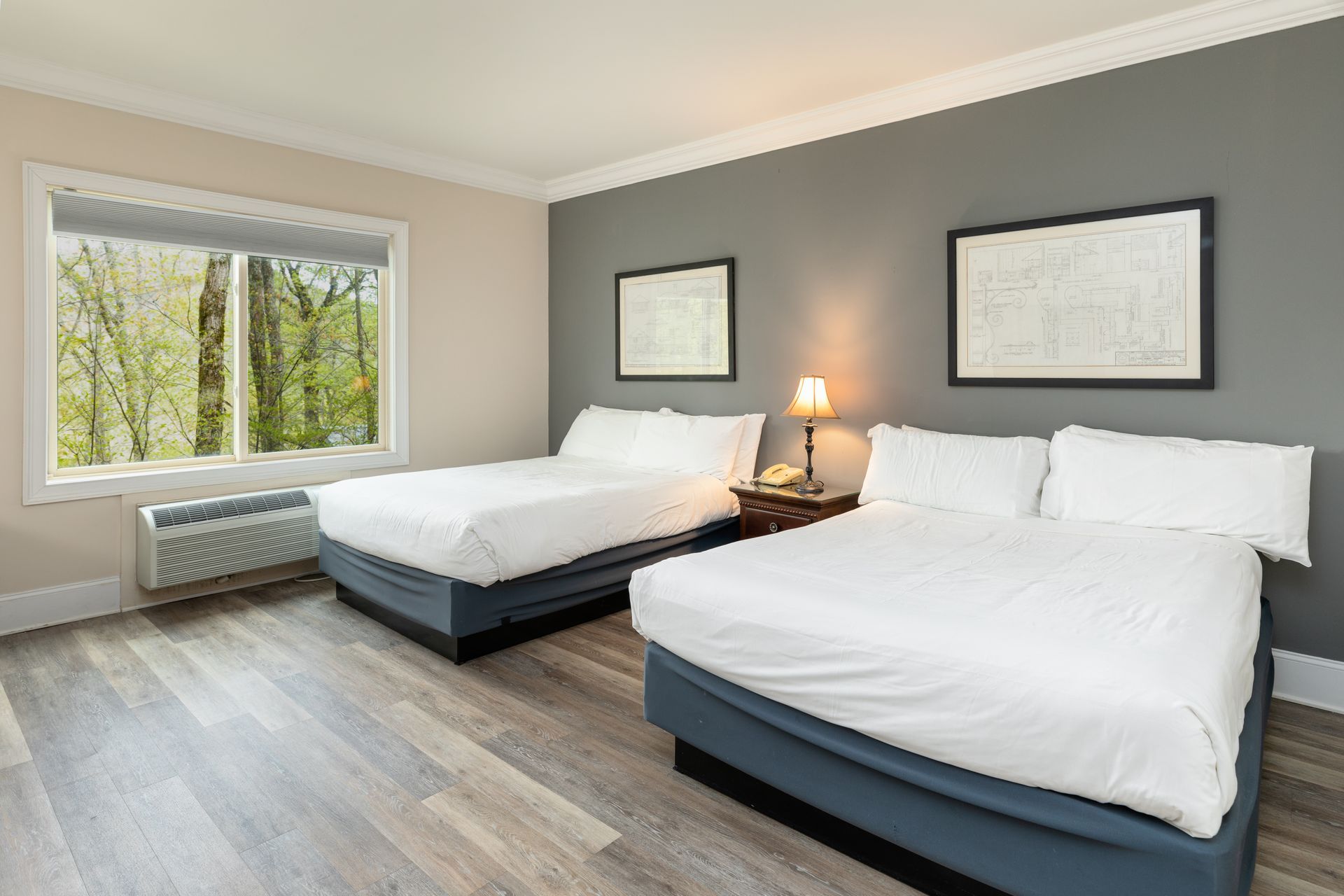 A hotel room with two beds and a window.