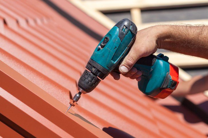 An Electric Drill Installing Roof — Metal Roofing in Twin Falls, ID