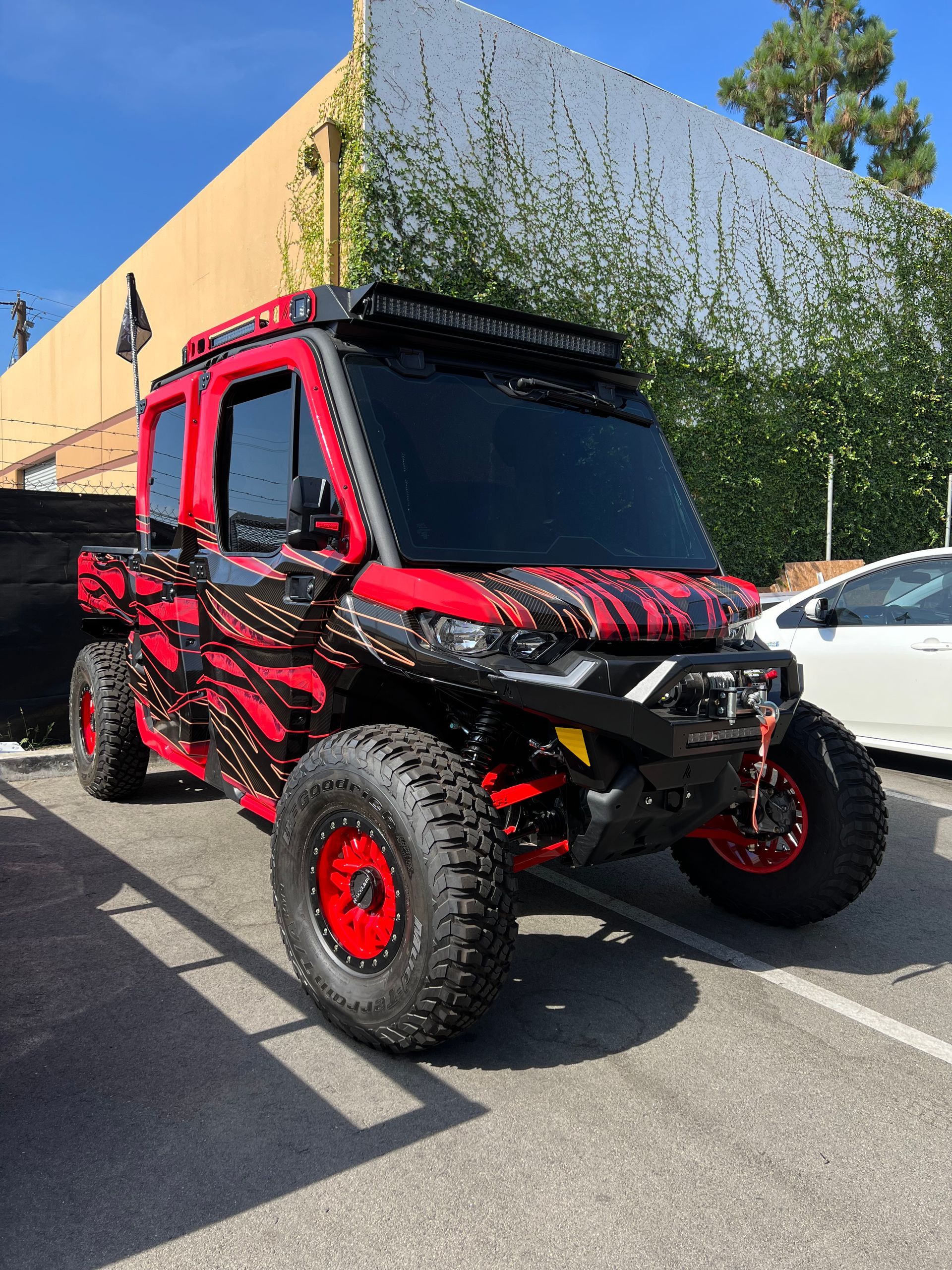 A red atv is parked in a parking lot in front of a building.