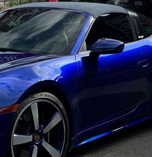 Blue Porsche convertible with silver and blue wheels.