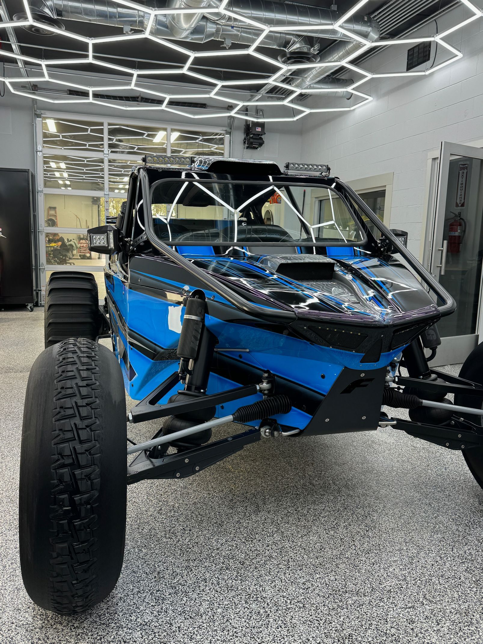 A blue atv is parked in a garage.