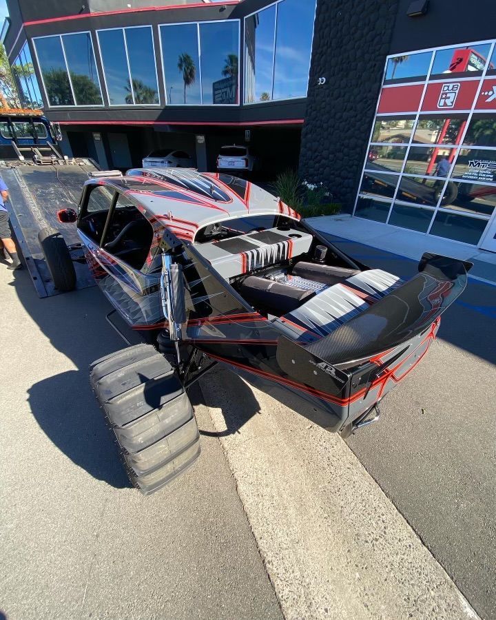 A monster truck is parked in front of a building.