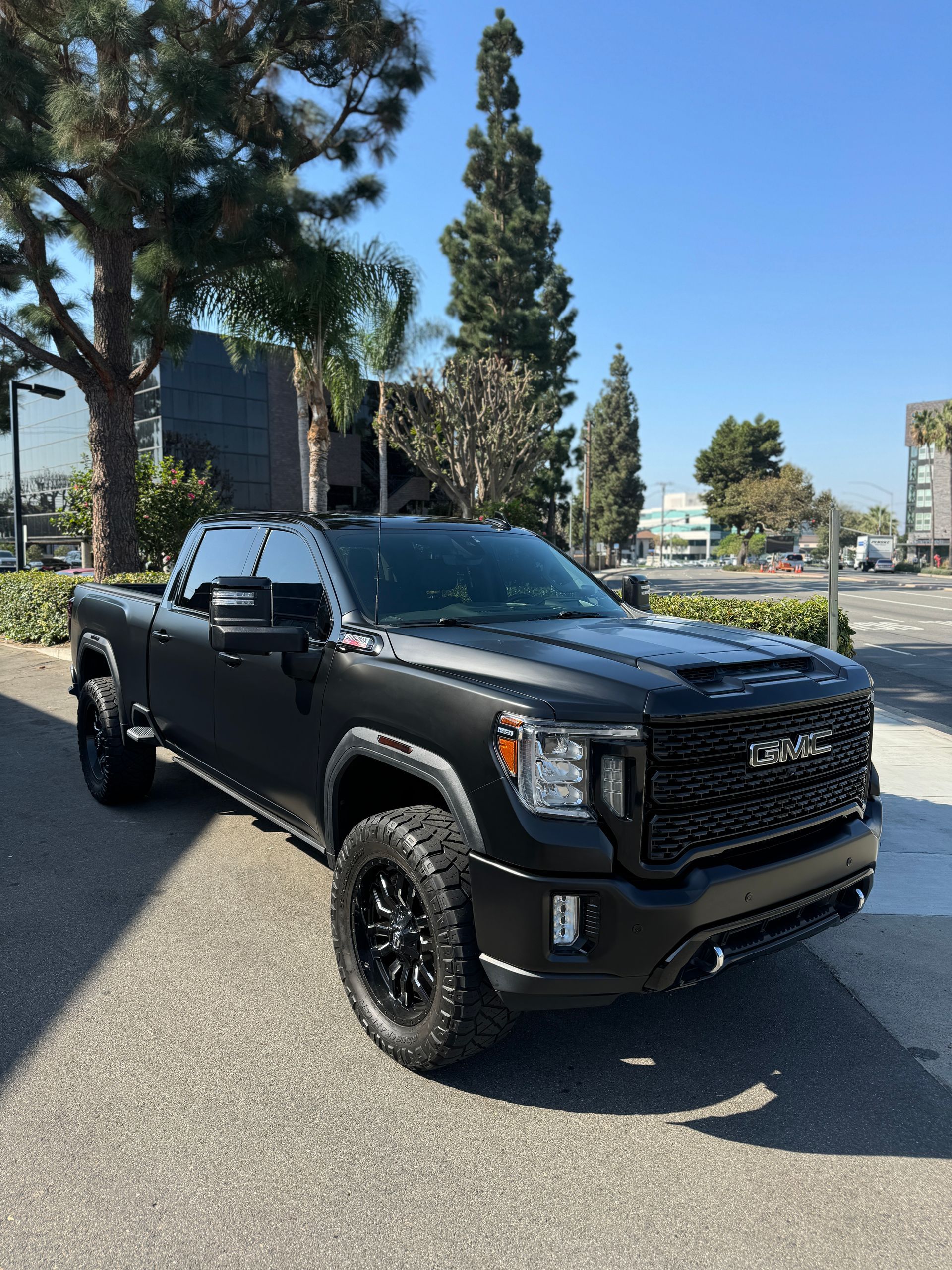 A black truck is parked on the side of the road.