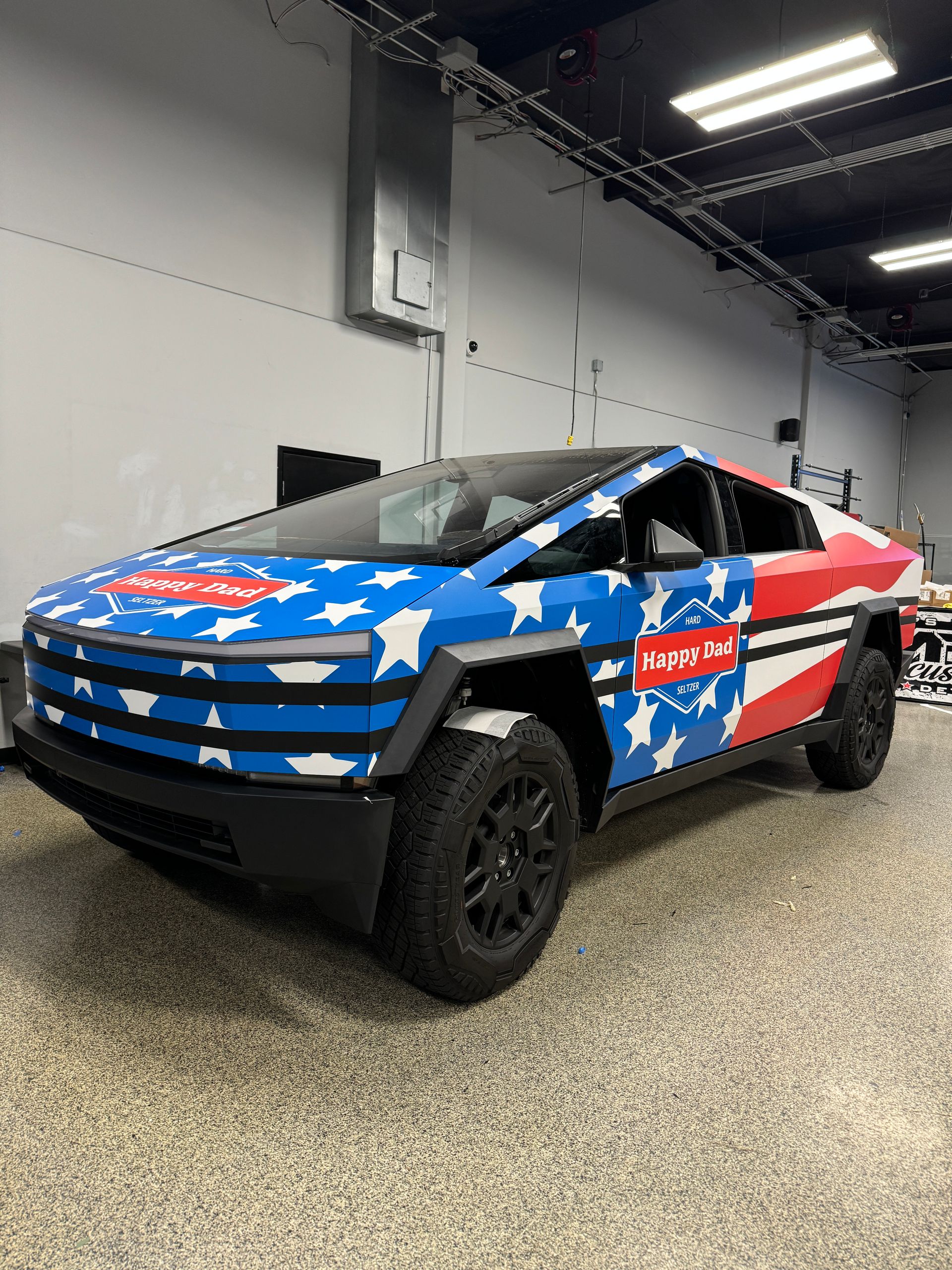 A white truck is parked in a parking lot in front of a building.