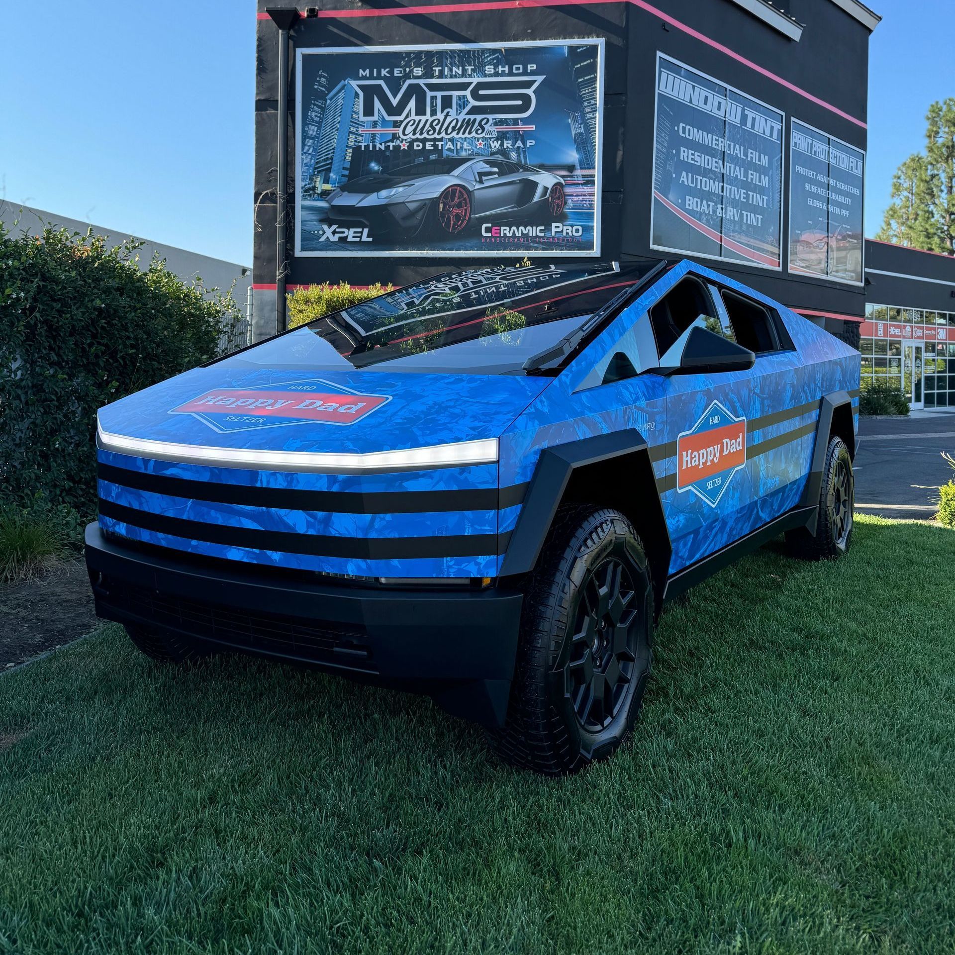A tesla model x is parked in front of a building with a sign that says mts