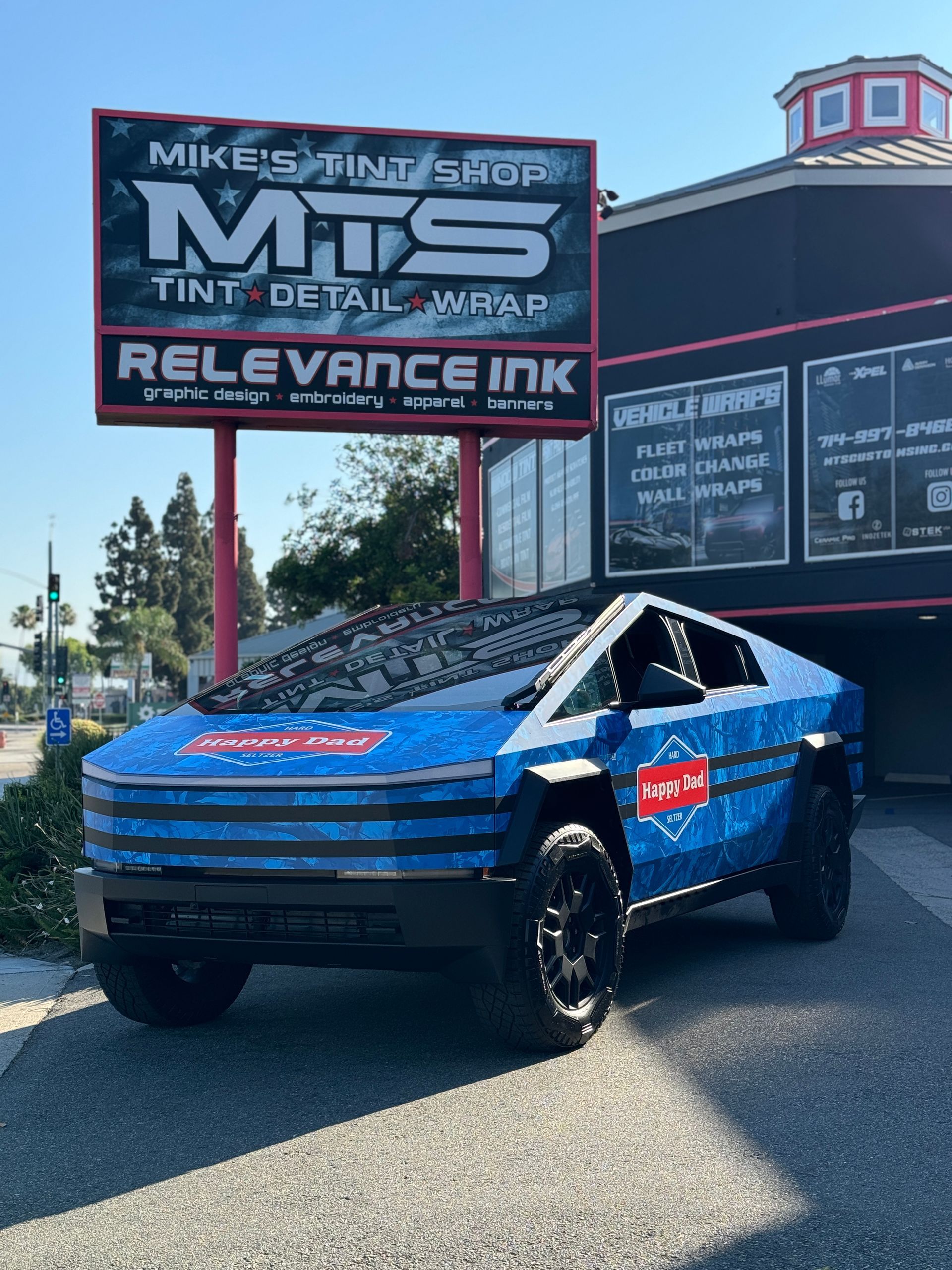 A tesla model s with an american flag wrap is parked in a garage.
