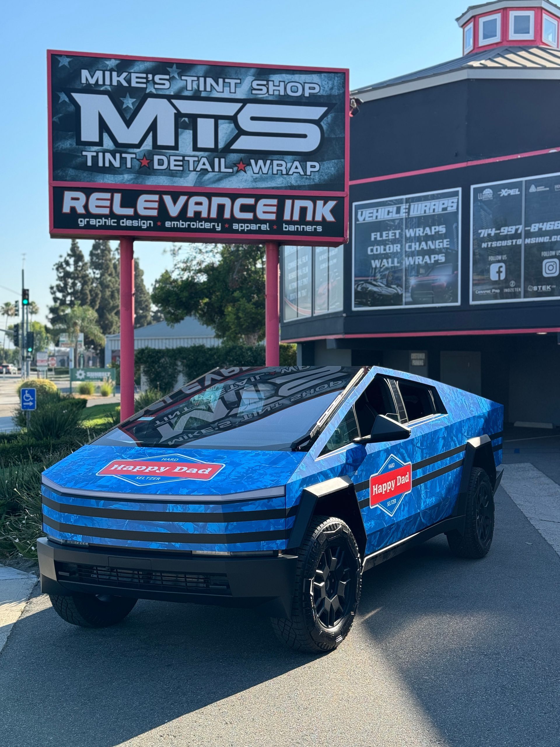 A white tesla cybertruck is parked in front of a building.