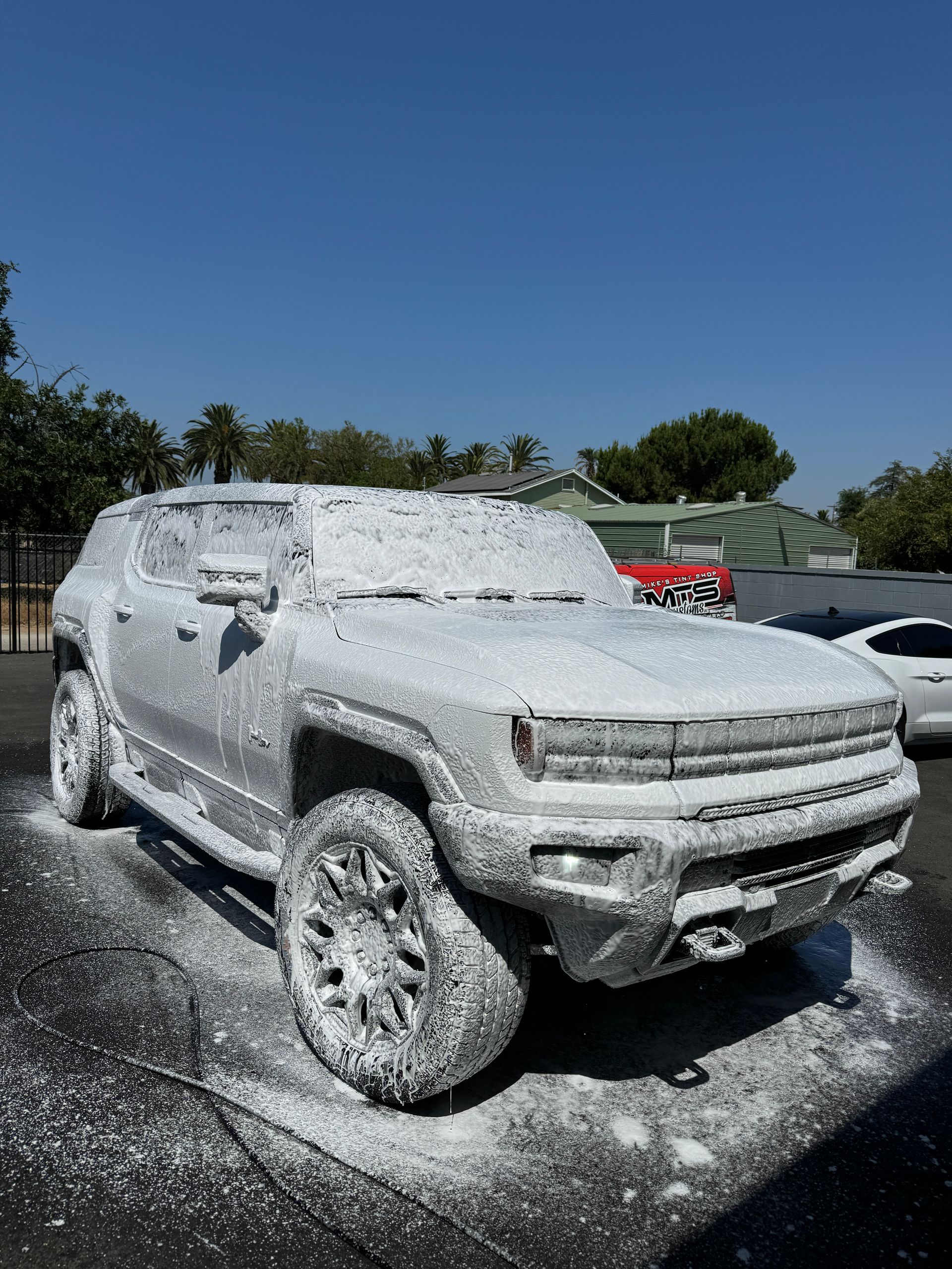 A truck covered in foam is parked in a parking lot