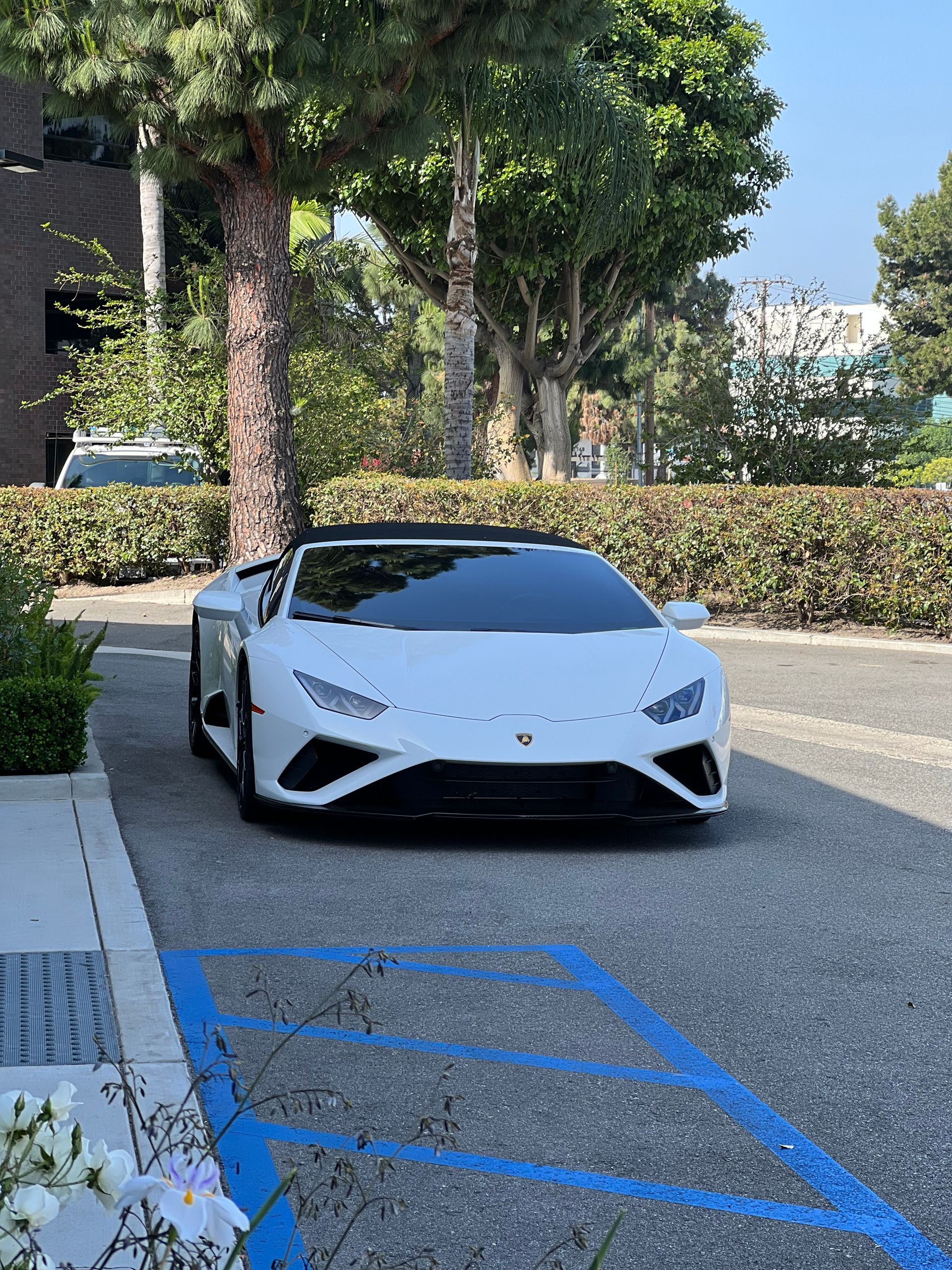 A white lamborghini huracan is parked in a parking lot.