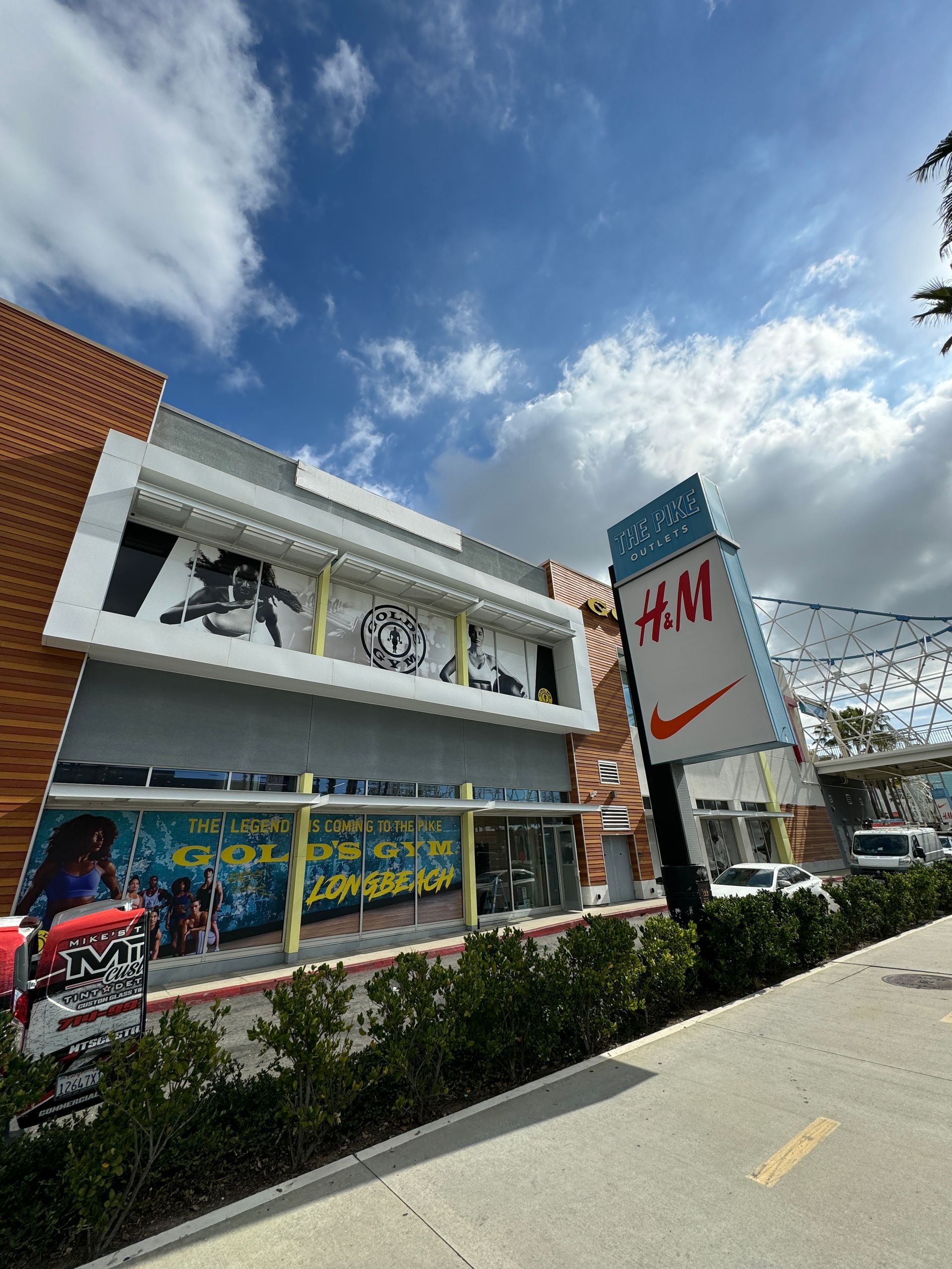 A h & m store with a nike sign in front of it.