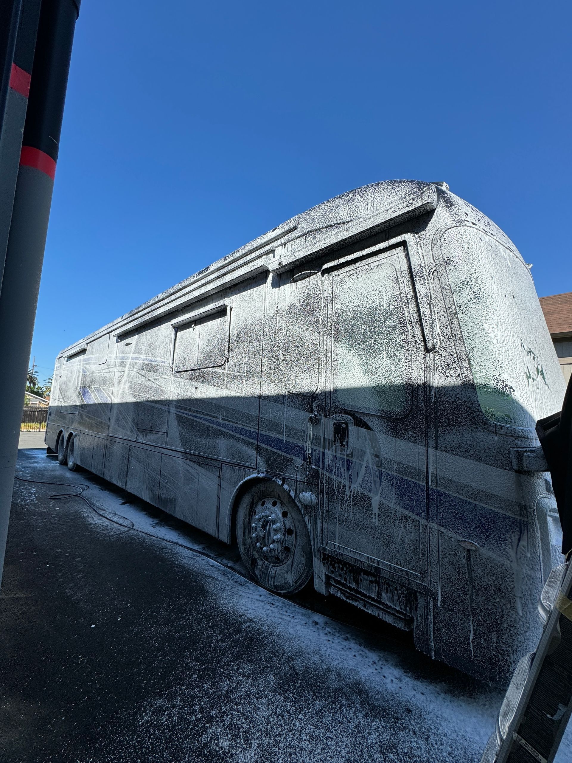 A bus covered in foam is parked on the side of the road.