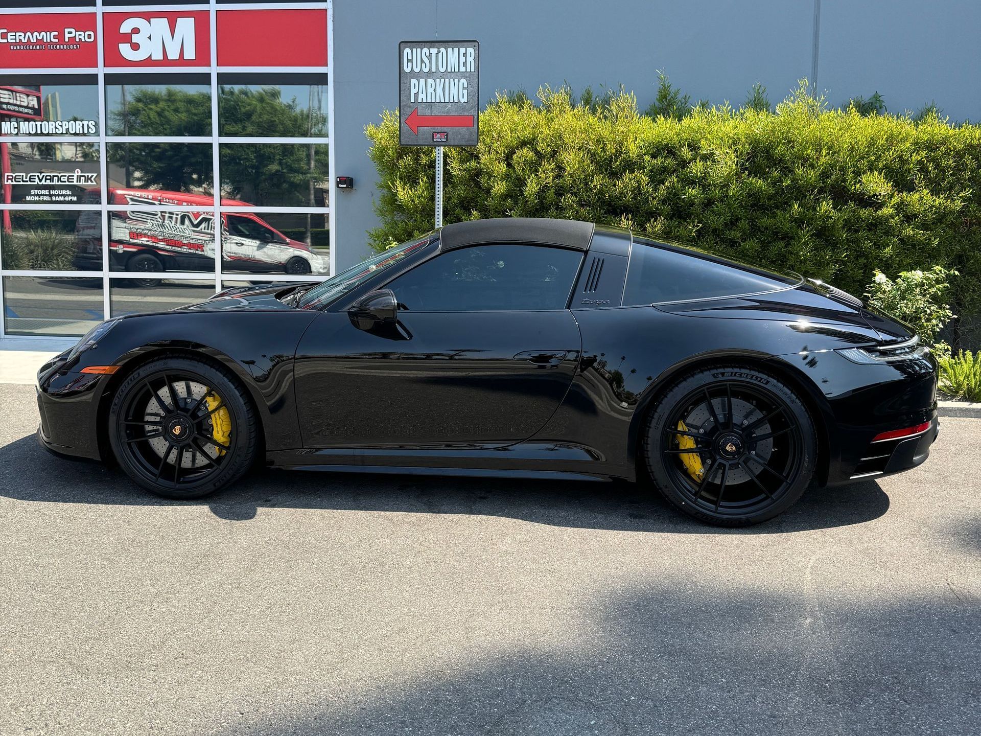 A person is applying tinted window film to a car window.