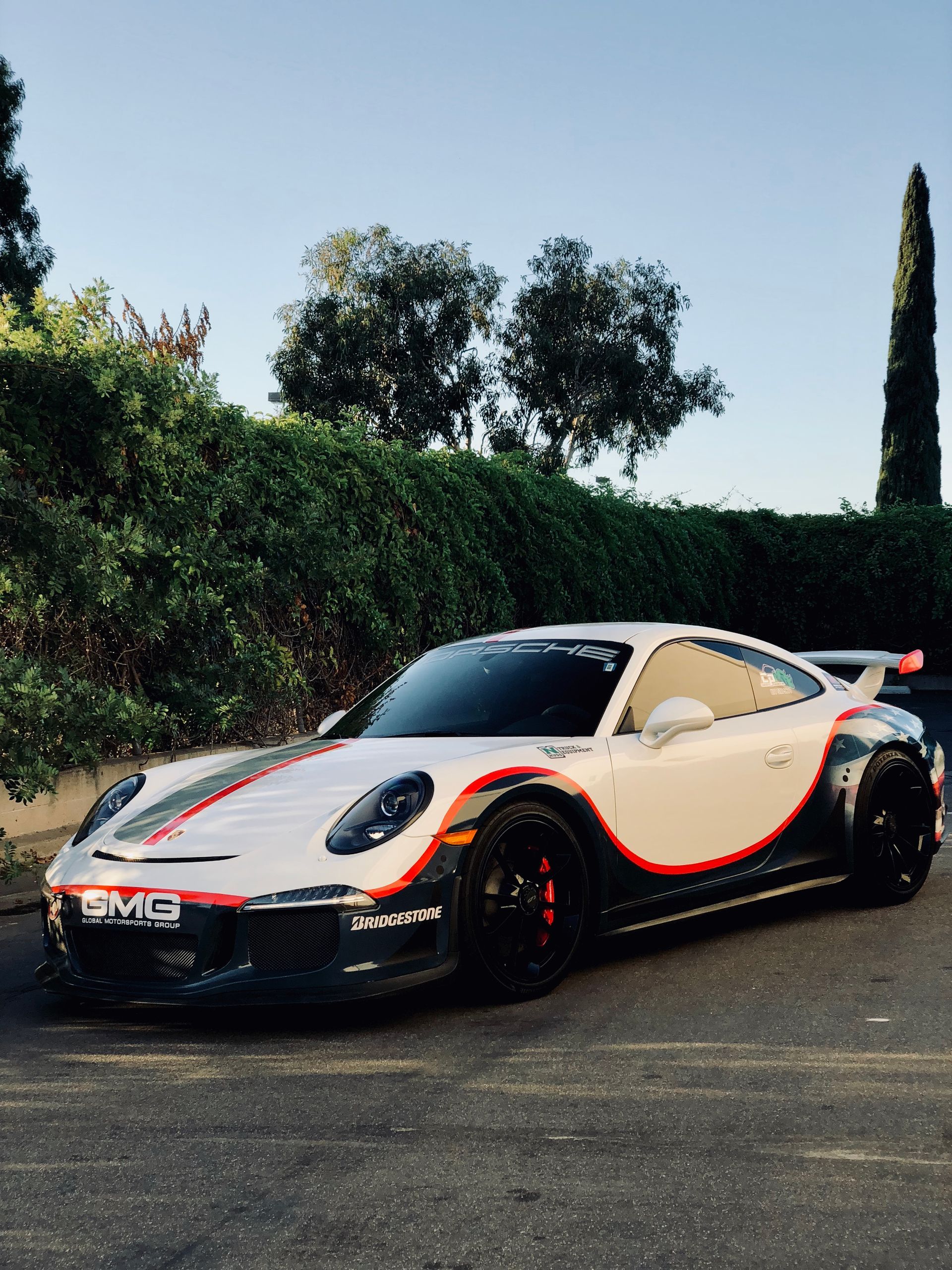 A blue tesla model s is parked in front of a building.