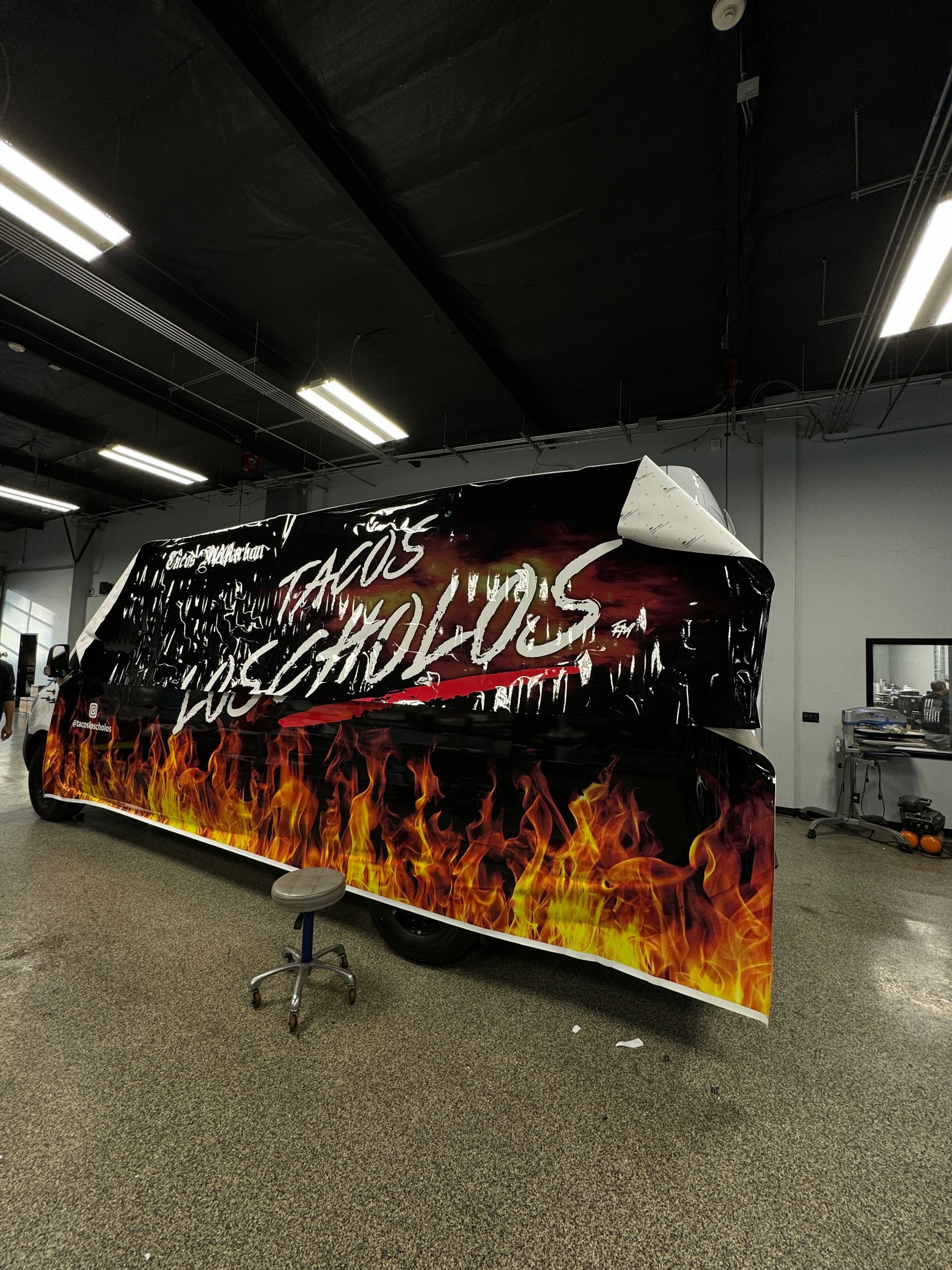 A large sign with flames on it is sitting in a room.