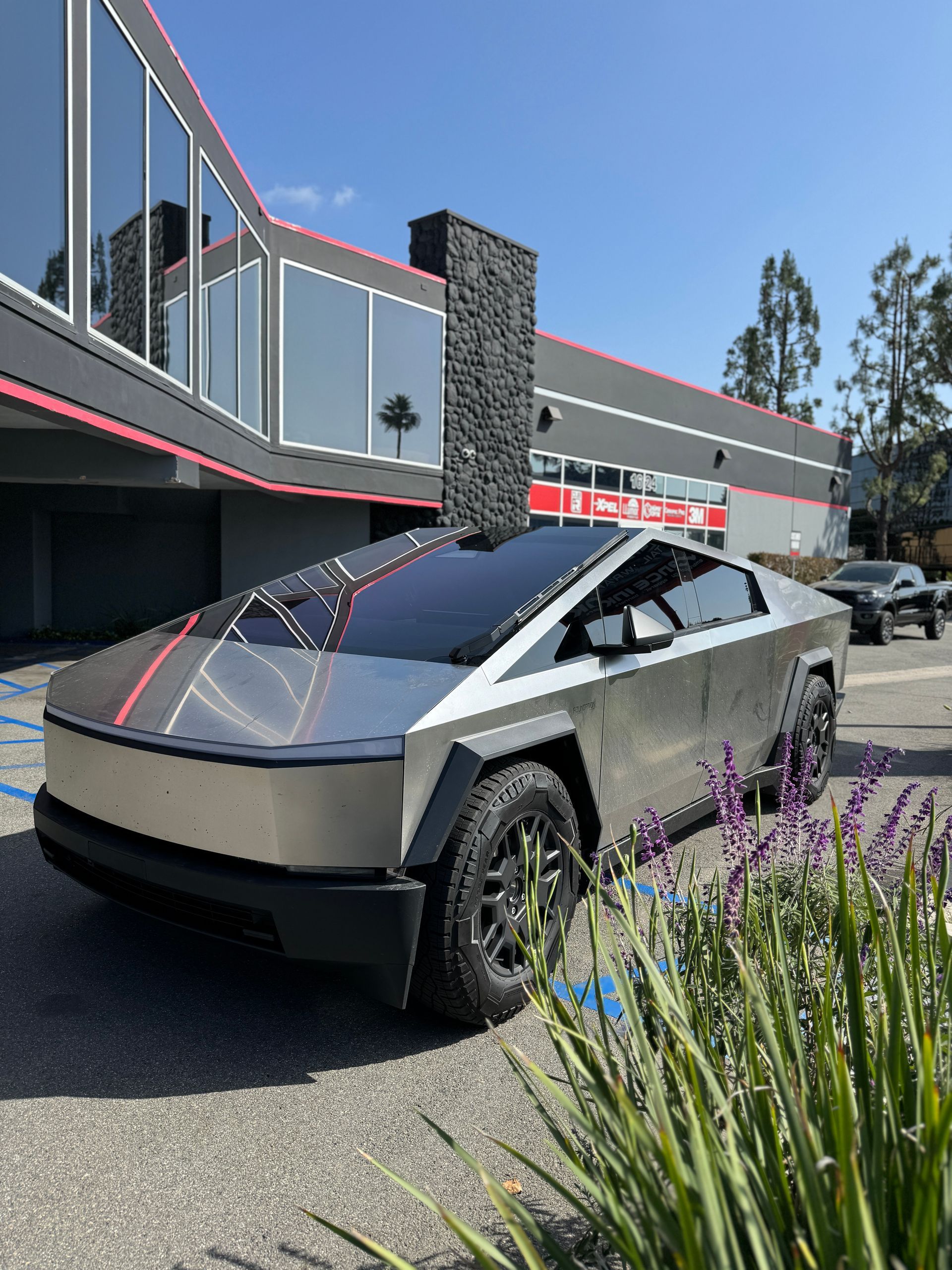 A blue and white truck is parked in front of a building.