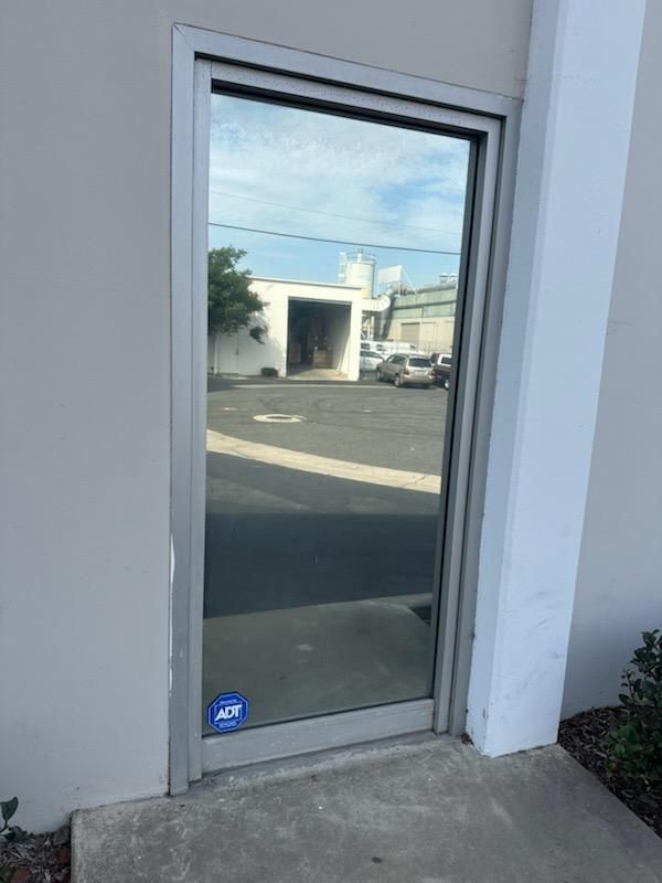 A door with a reflection of a parking lot in it