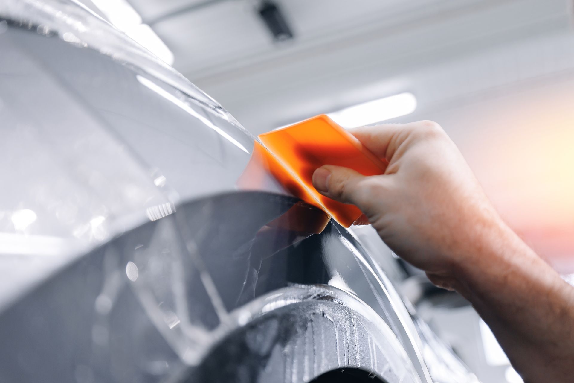 A black lamborghini aventador is parked in a garage next to a rack of tires.