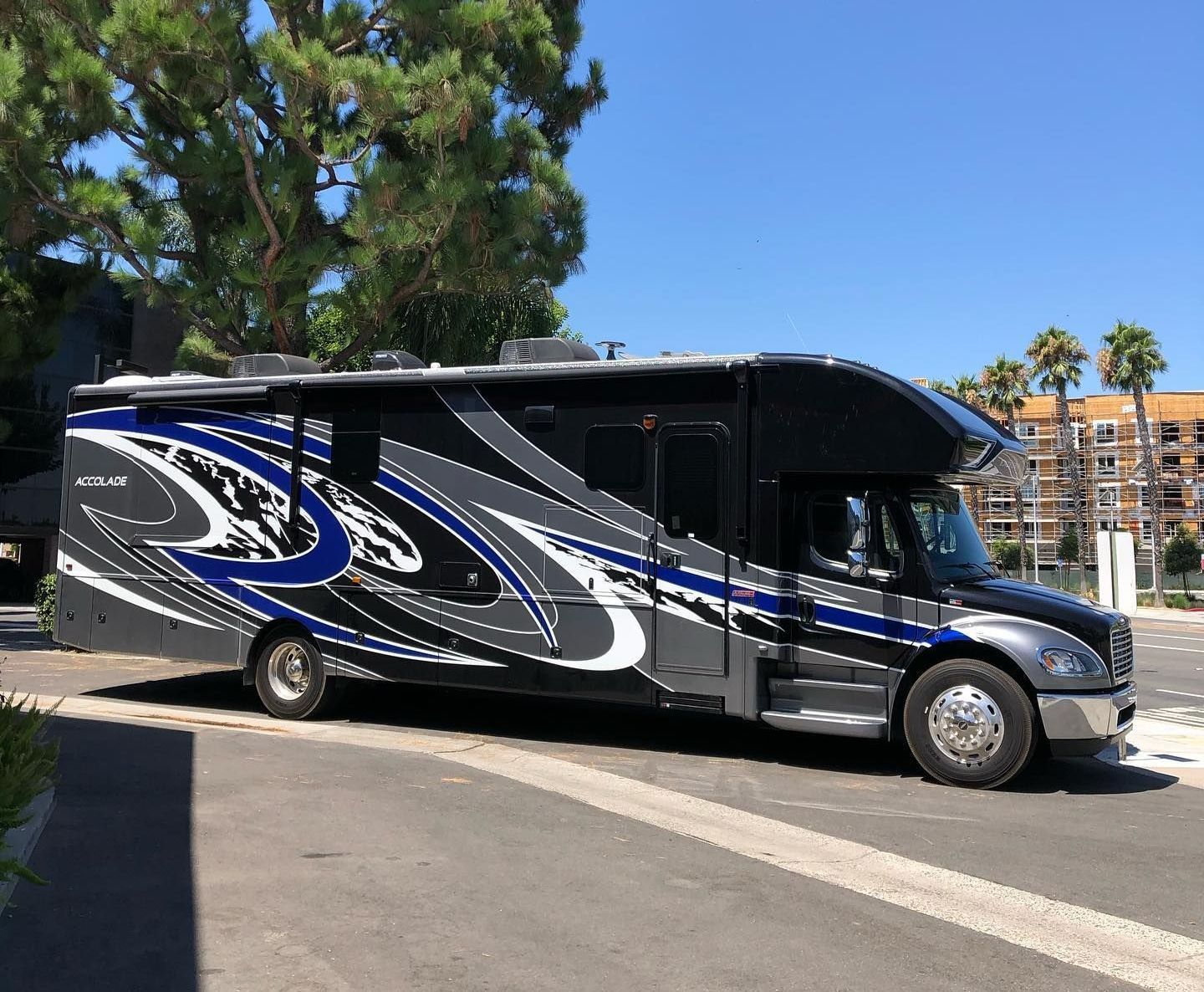 A blue jeep is parked in the grass in front of a building.