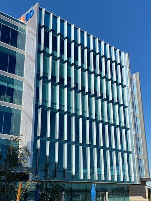 A large building with a lot of windows and a blue sky in the background