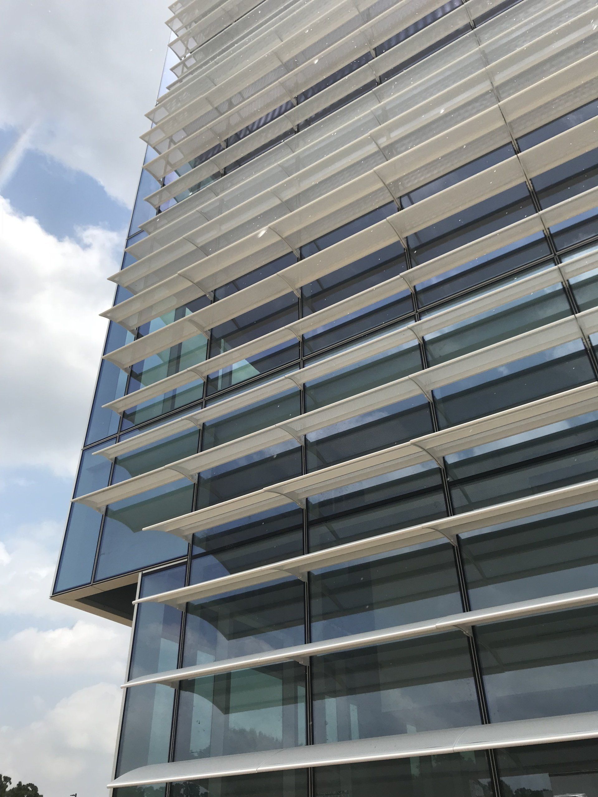 A tall building with a lot of windows and a blue sky in the background