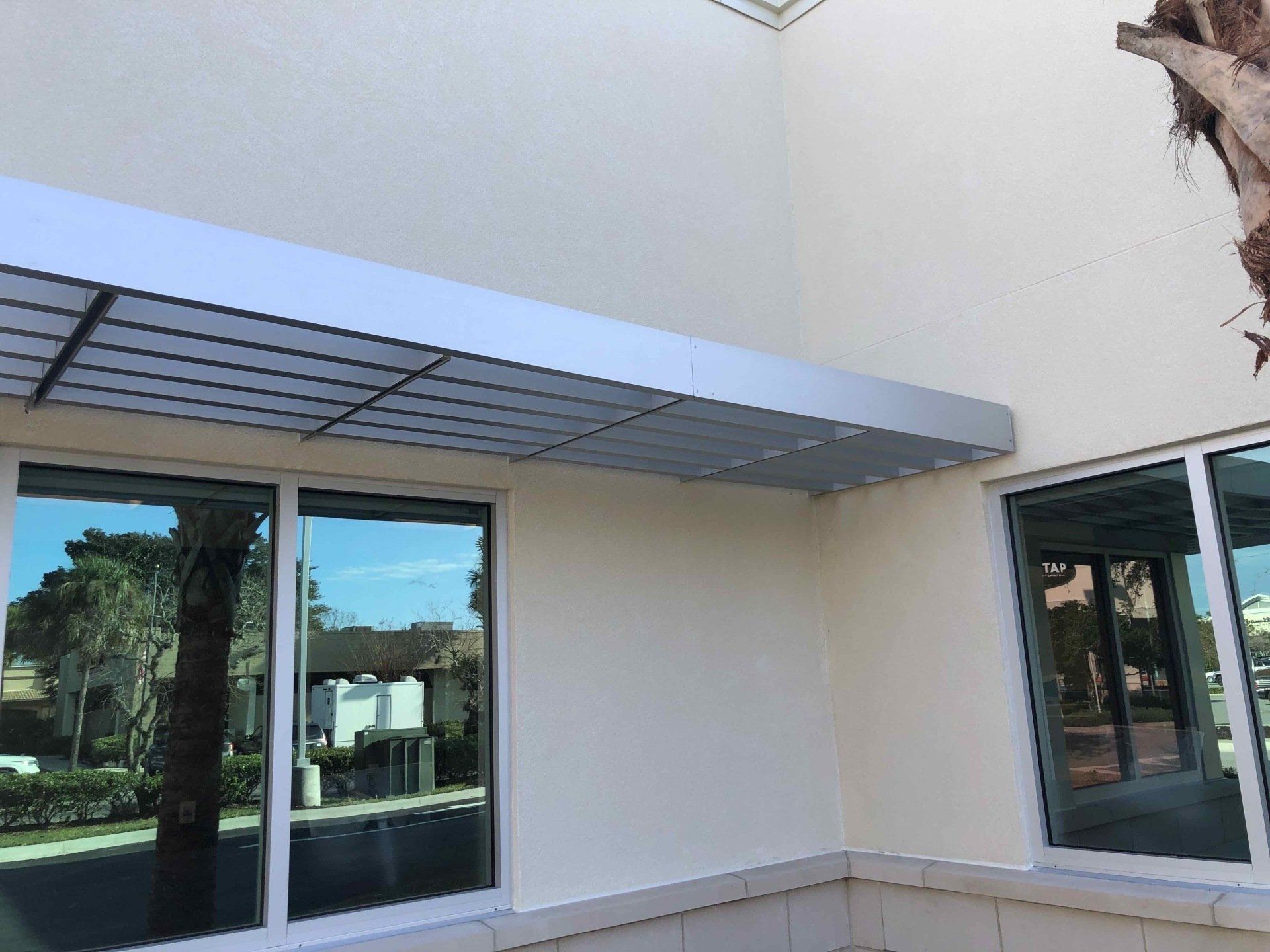 A white building with a canopy over the windows