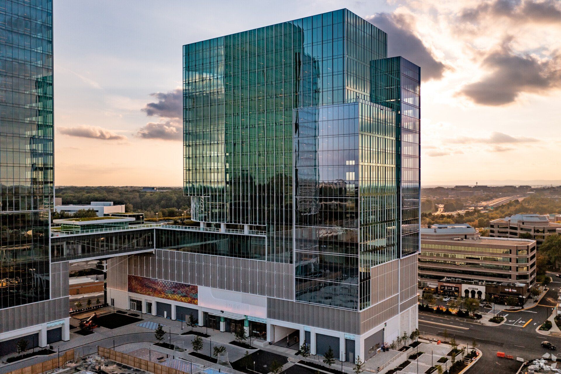 An aerial view of a large glass building in a city.