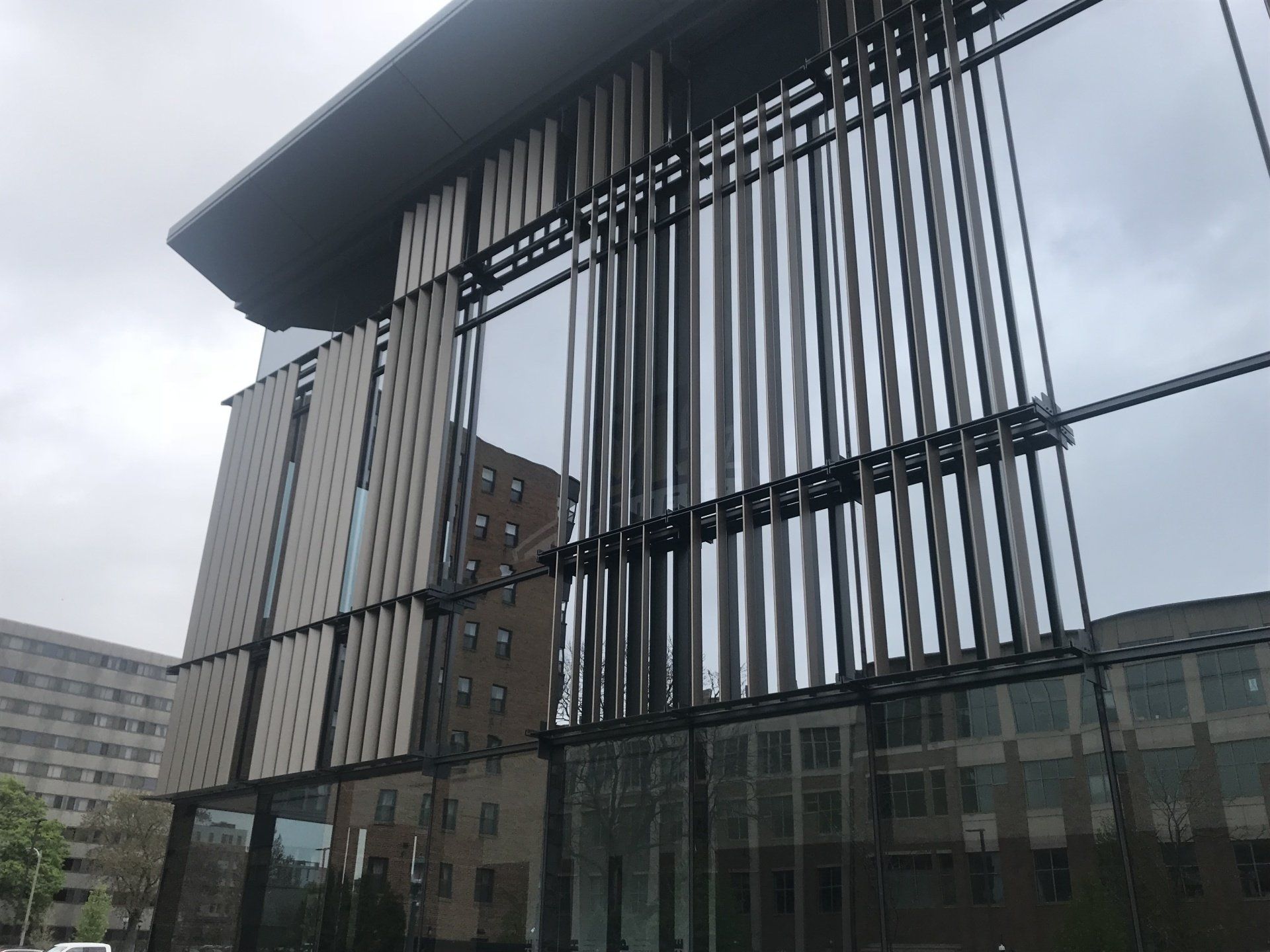 A large building with a lot of windows and a gray sky in the background.