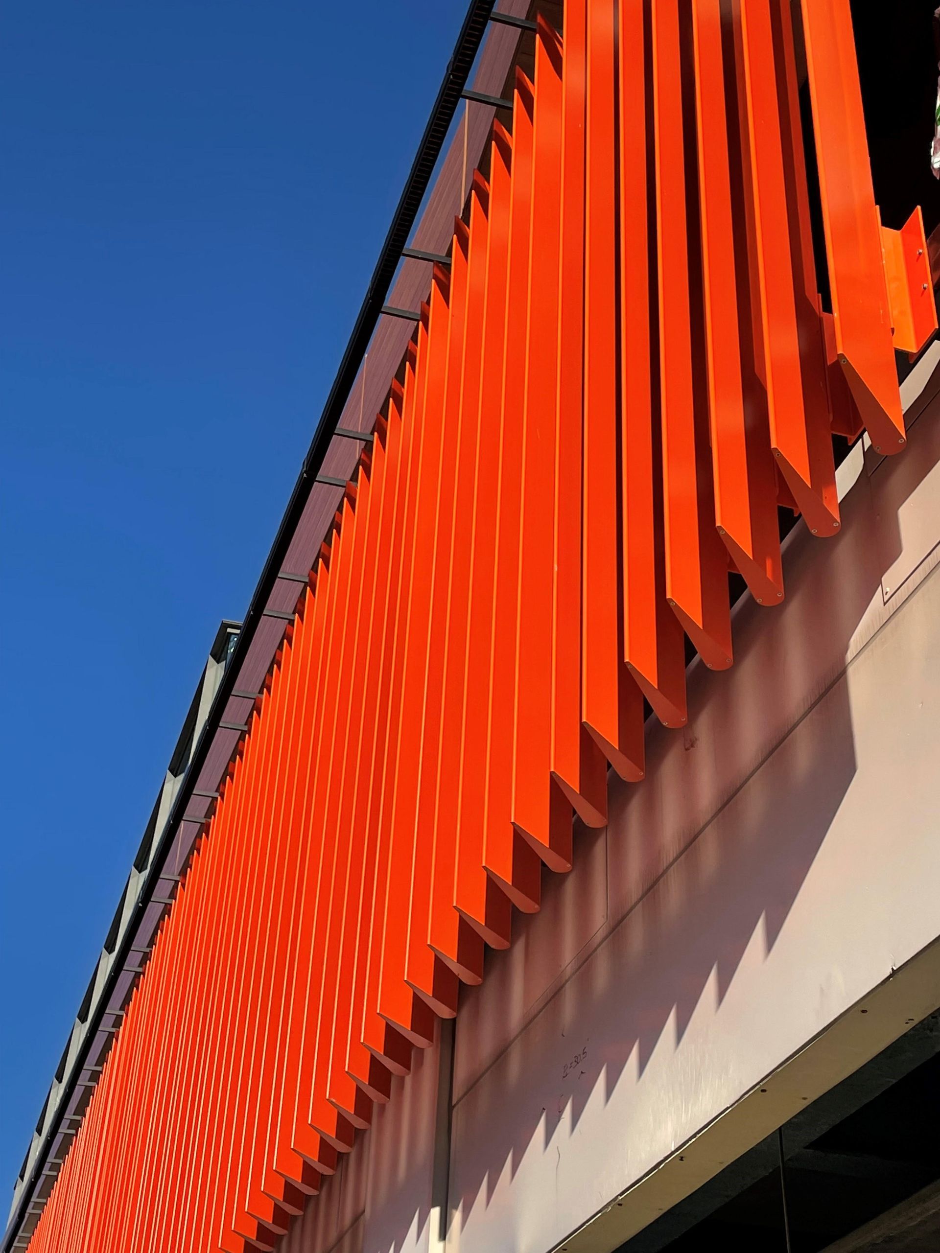 A close up of an orange building with a blue sky in the background