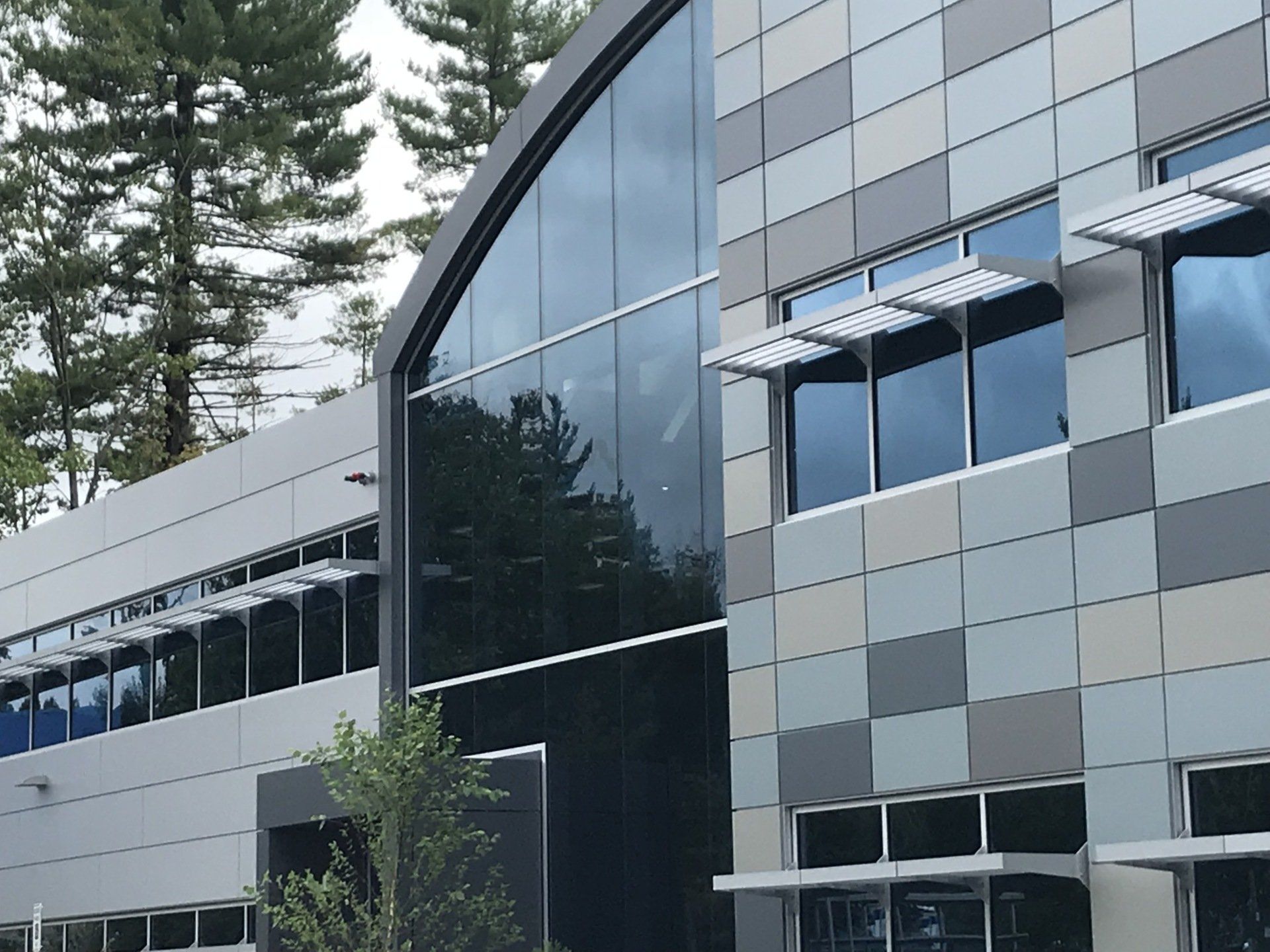 A large building with a lot of windows and trees in the background