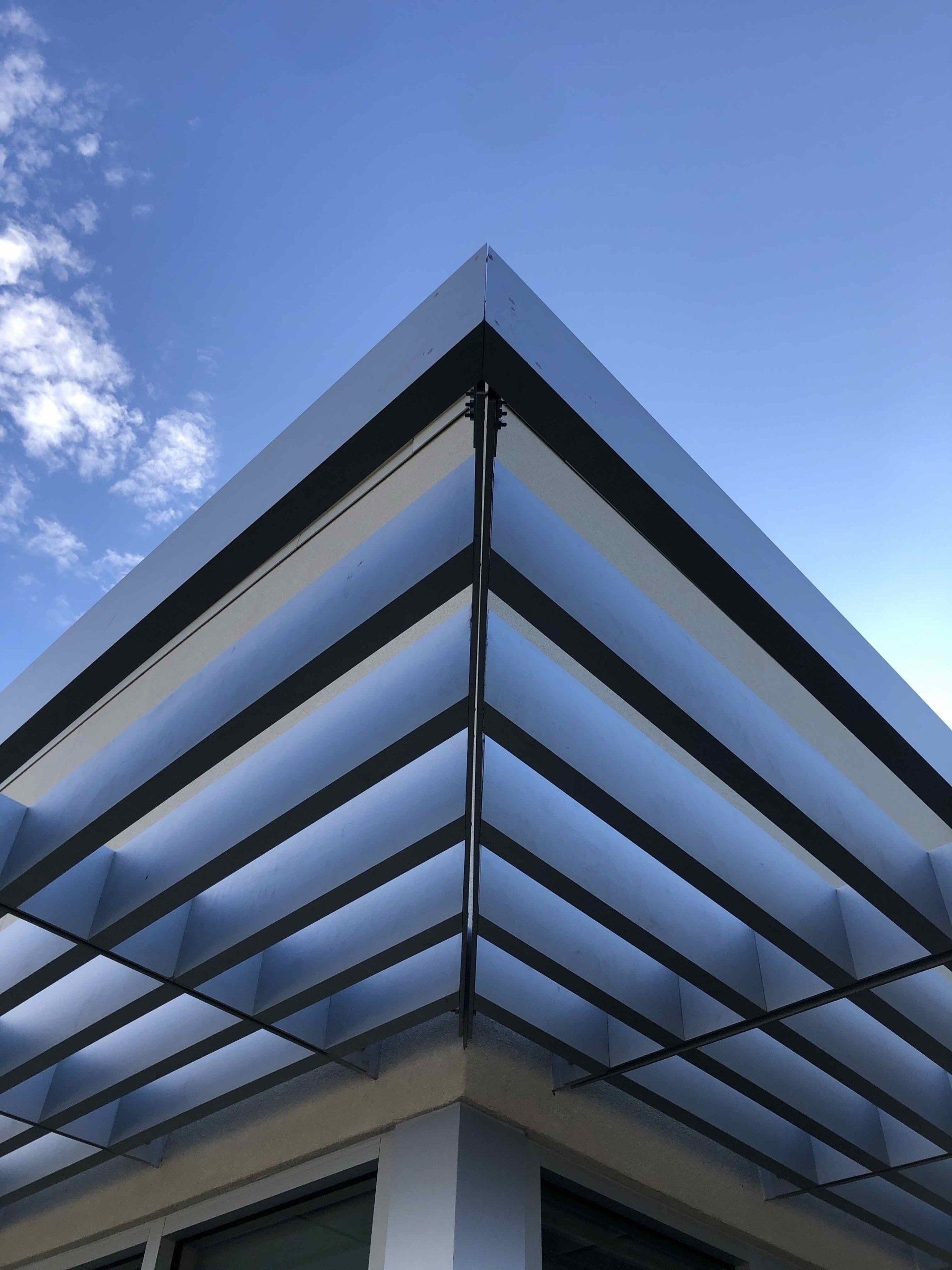 A building with a clear roof and a blue sky in the background