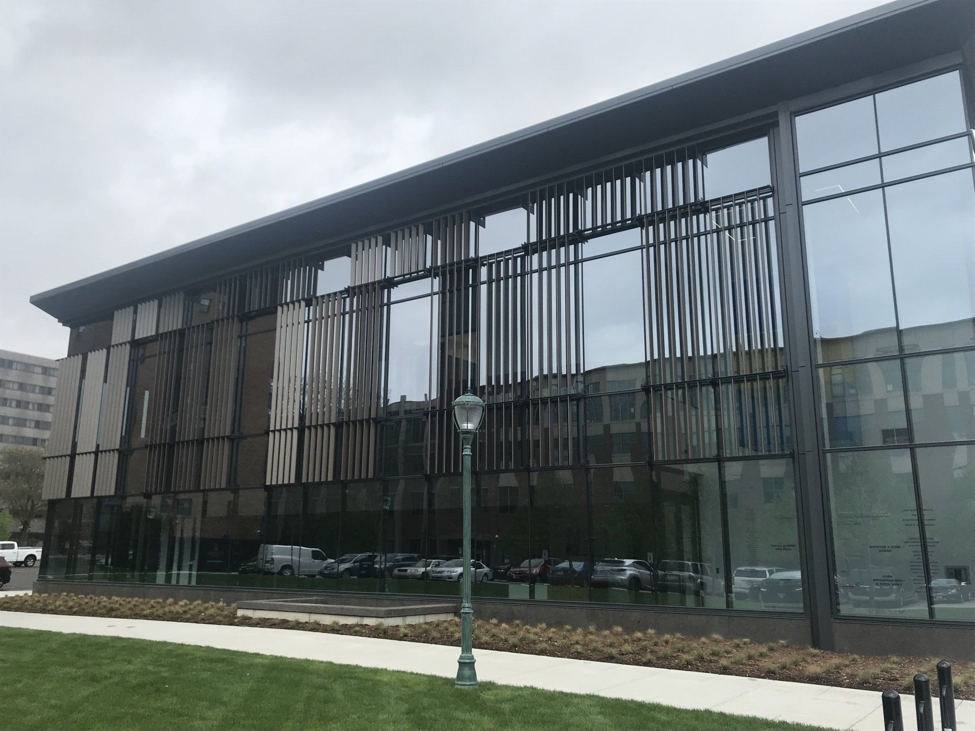 A large glass building with a lot of windows is sitting on top of a lush green field.