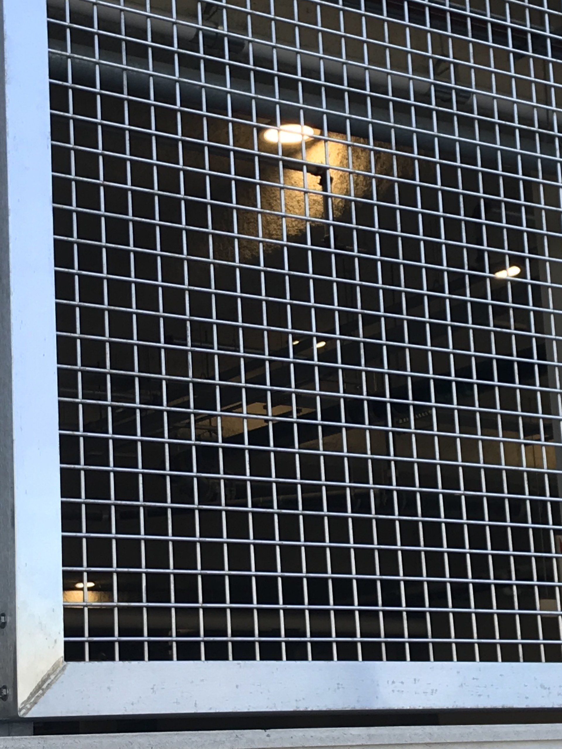 A close up of a metal grid with a light behind it
