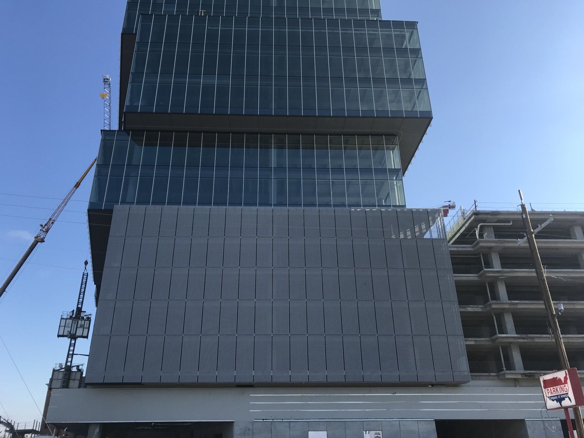 A tall building under construction with a crane in front of it.