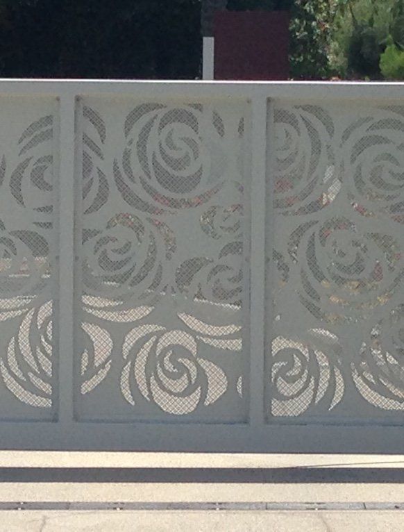 A white fence with a pattern of roses on it