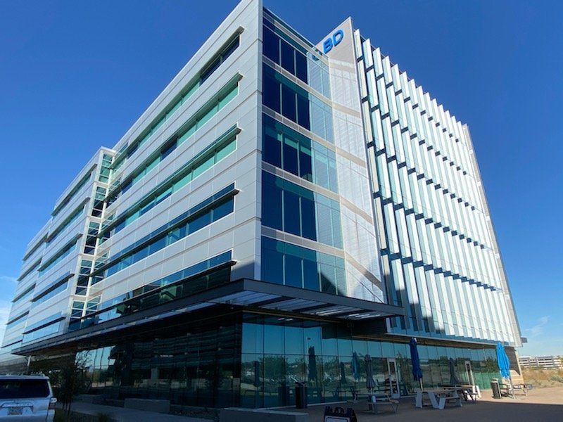 A large building with a lot of windows and a blue sky in the background