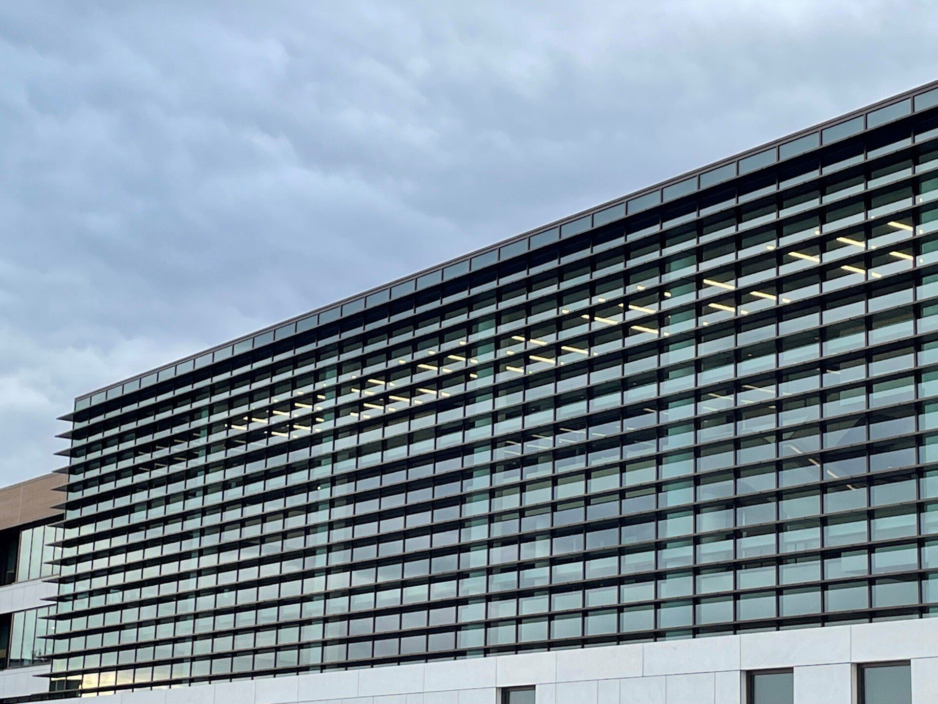 A large building with a lot of windows and a blue sky in the background.