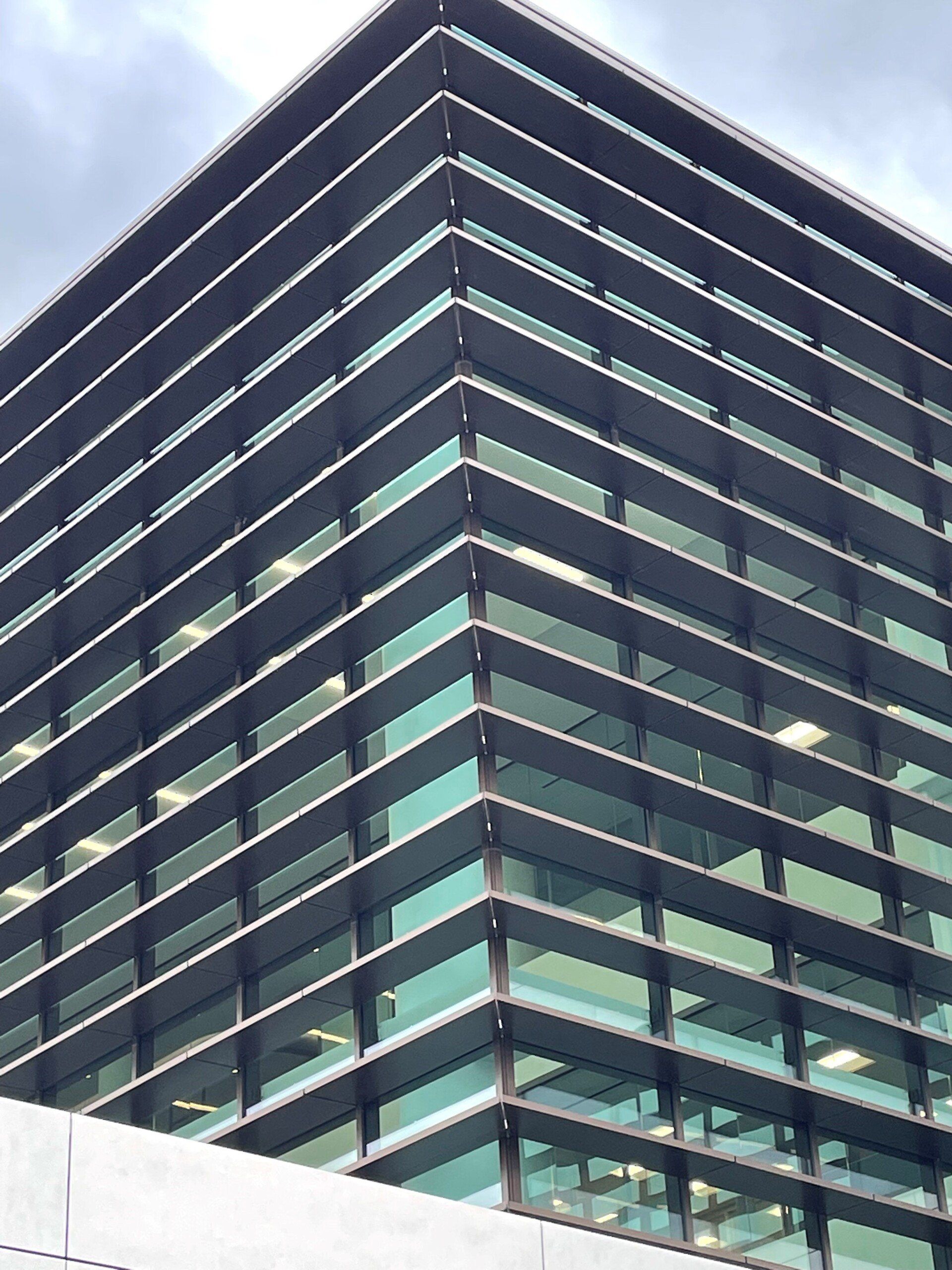 A large building with a lot of windows and a blue sky in the background