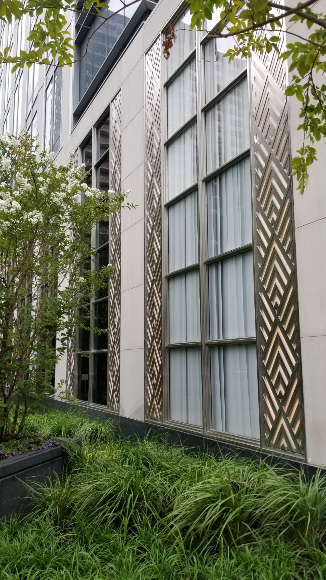 A building with a lot of windows and a geometric design on the side of it.