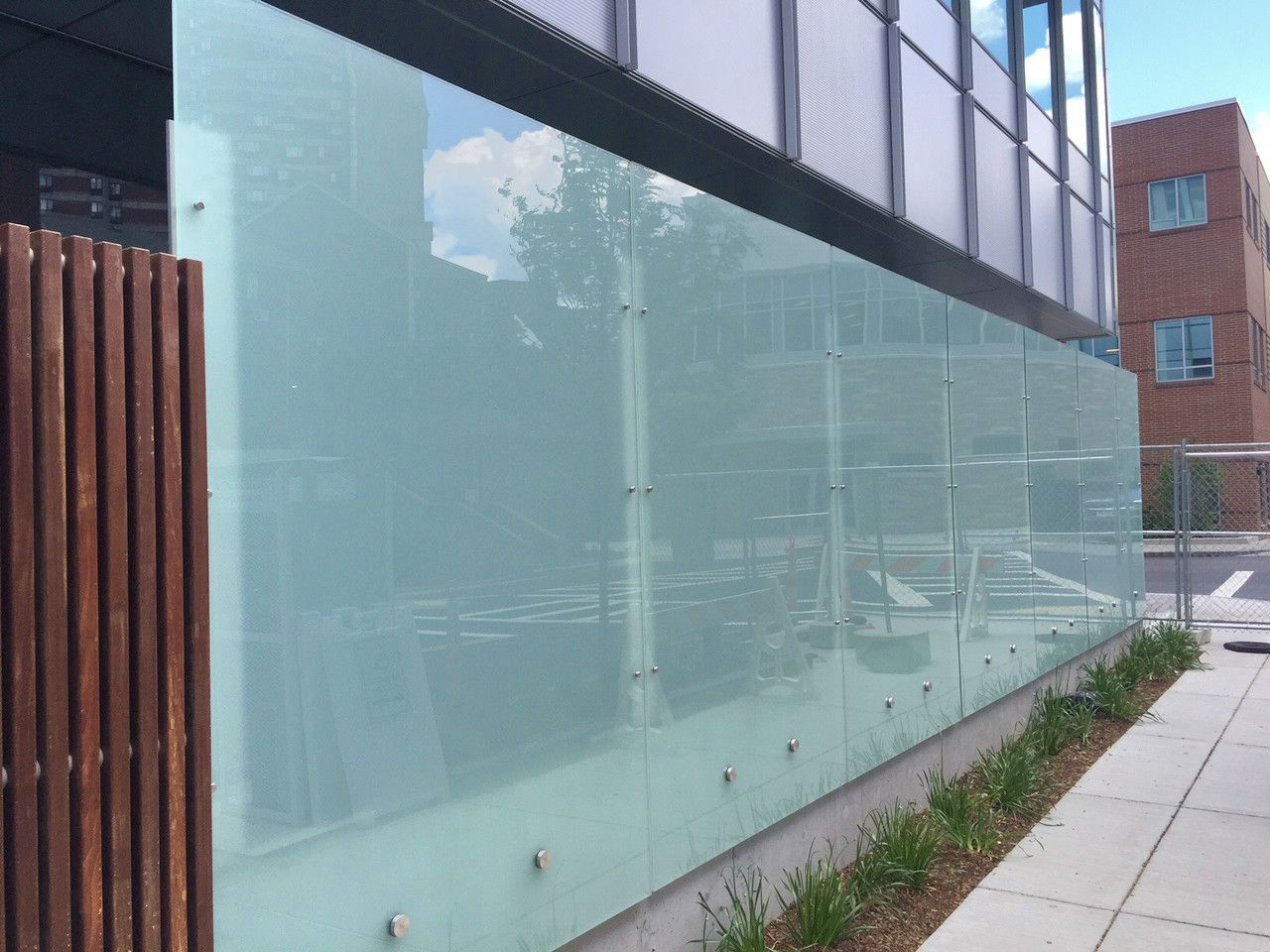 A glass wall with a wooden fence in front of a building