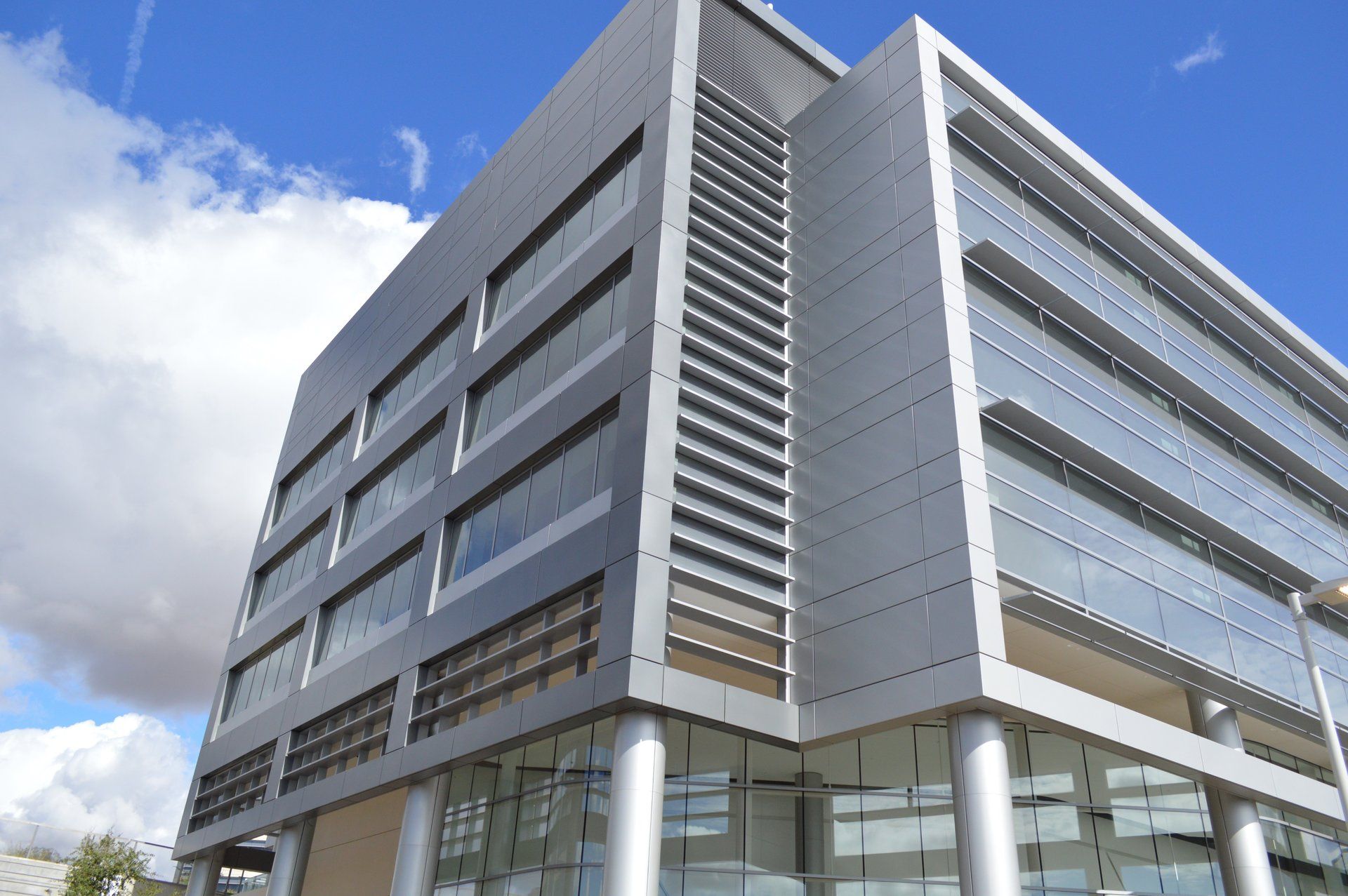 A large building with a lot of windows and a blue sky in the background