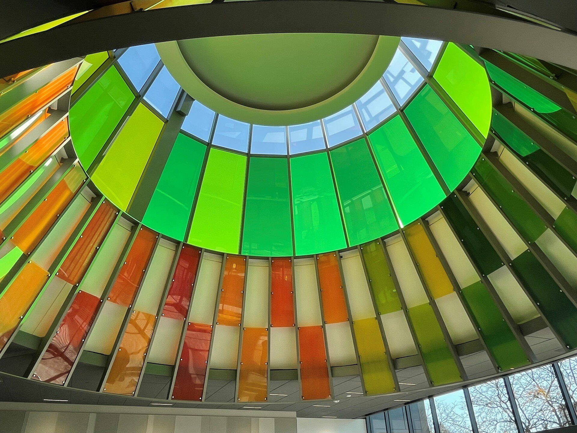 Looking up at the ceiling of a building with colorful glass panels