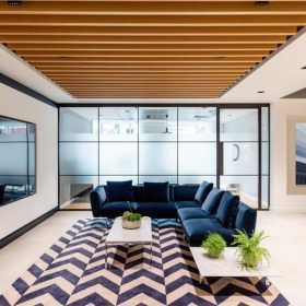 A living room with a blue couch and a chevron rug