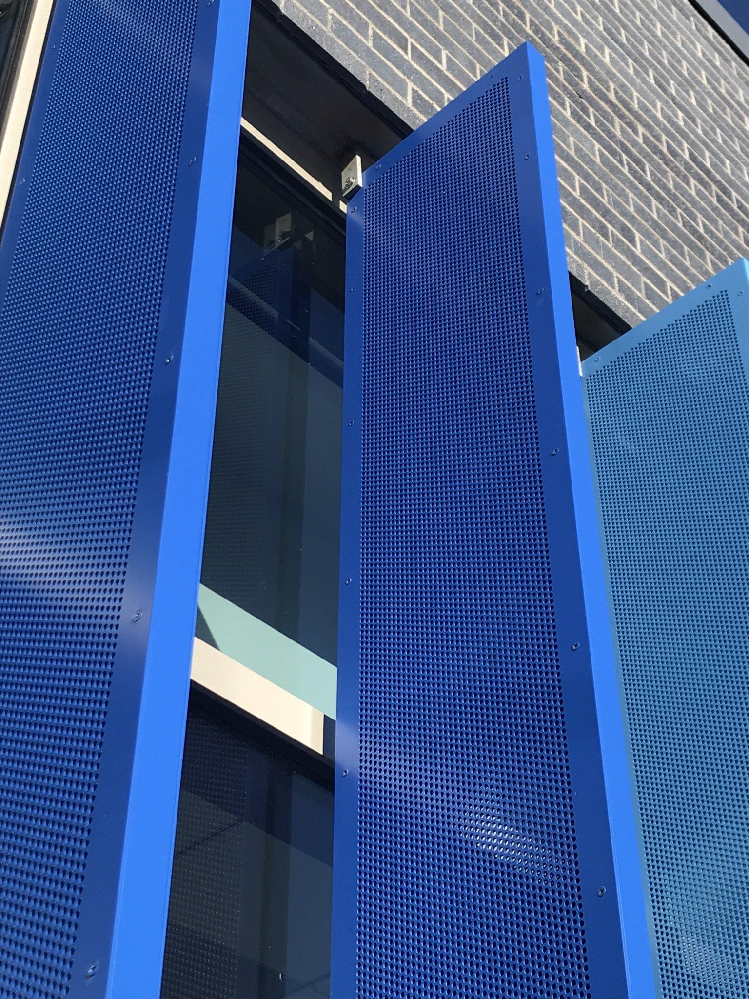 A building with a blue fence and a brick wall